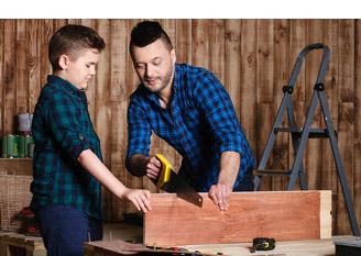 man and child cutting wood with saw