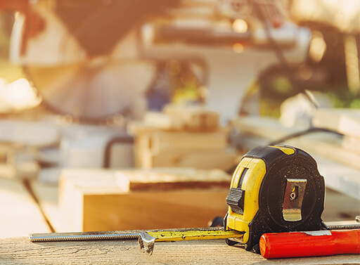 A selection of tools including measuring tape and table saw