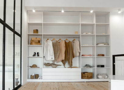 A large wooden closet with open shelves and clothes hanging on a rail - Timber Mart